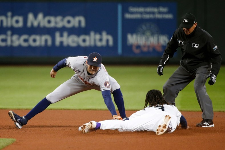 Aug 31, 2021; Seattle, Washington, USA; Houston Astros shortstop Carlos Correa (1) tags out Seattle Mariners shortstop J.P. Crawford (3) on a stolen base attempt during the third inning at T-Mobile Park. Mandatory Credit: Joe Nicholson-USA TODAY Sports