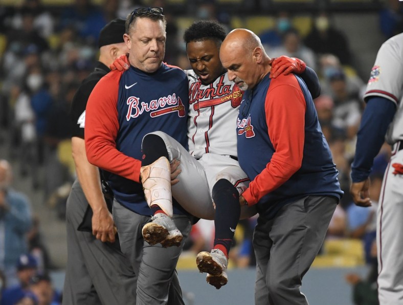 Aug 31, 2021; Los Angeles, California, USA; Atlanta Braves second baseman Ozzie Albies (1) is helped to the clubhouse after hitting his knee with a foul ball hit during the fifth inning at Dodger Stadium. Mandatory Credit: Richard Mackson-USA TODAY Sports