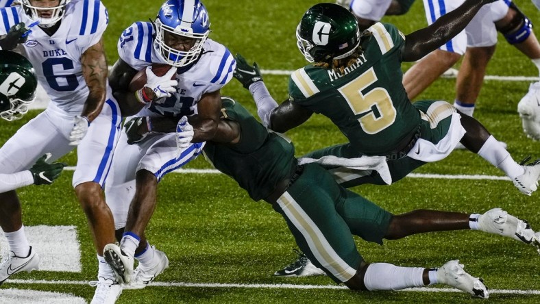 Sep 3, 2021; Charlotte, North Carolina, USA; Duke Blue Devils running back Mataeo Durant (21) is tackled by Charlotte 49ers defensive back Jonathan Alexander (1) during the second quarter at Jerry Richardson Stadium. Mandatory Credit: Jim Dedmon-USA TODAY Sports