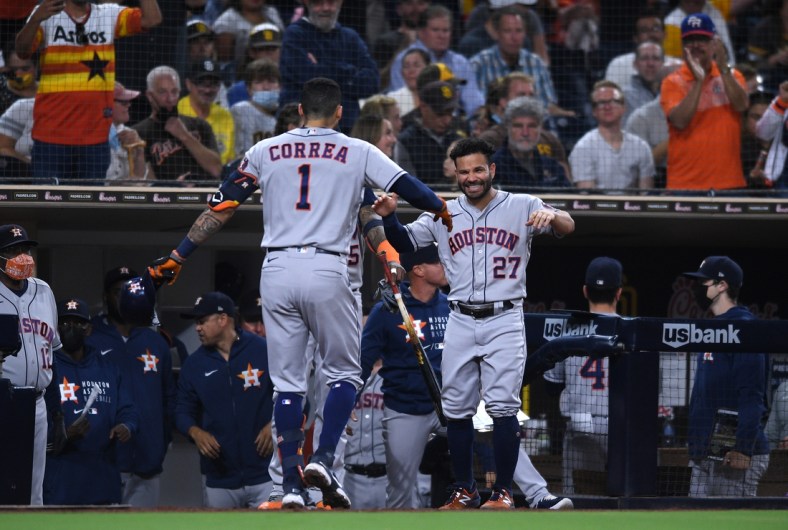 Sep 3, 2021; San Diego, California, USA; Houston Astros shortstop Carlos Correa (1) is greeted at the dugout by second baseman Jose Altuve (27) after hitting a three-run home run against the San Diego Padres during the fourth inning at Petco Park. Mandatory Credit: Orlando Ramirez-USA TODAY Sports