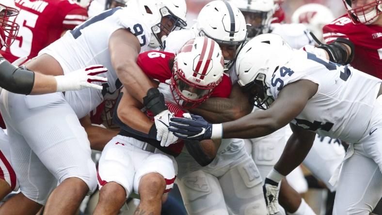 Sep 4, 2021; Madison, Wisconsin, USA;  Wisconsin Badgers running back Chez Mellusi (6) is tackled with the football during the first quarter against the Penn State Nittany Lions at Camp Randall Stadium. Mandatory Credit: Jeff Hanisch-USA TODAY Sports