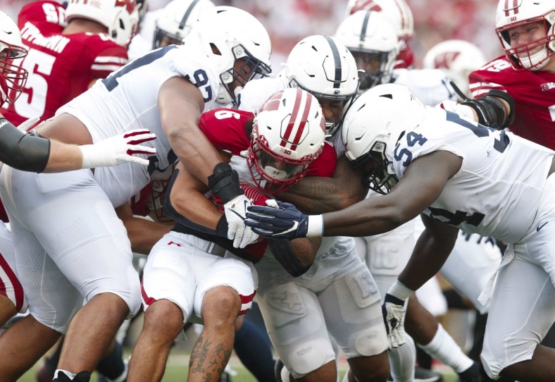 Sep 4, 2021; Madison, Wisconsin, USA;  Wisconsin Badgers running back Chez Mellusi (6) is tackled with the football during the first quarter against the Penn State Nittany Lions at Camp Randall Stadium. Mandatory Credit: Jeff Hanisch-USA TODAY Sports