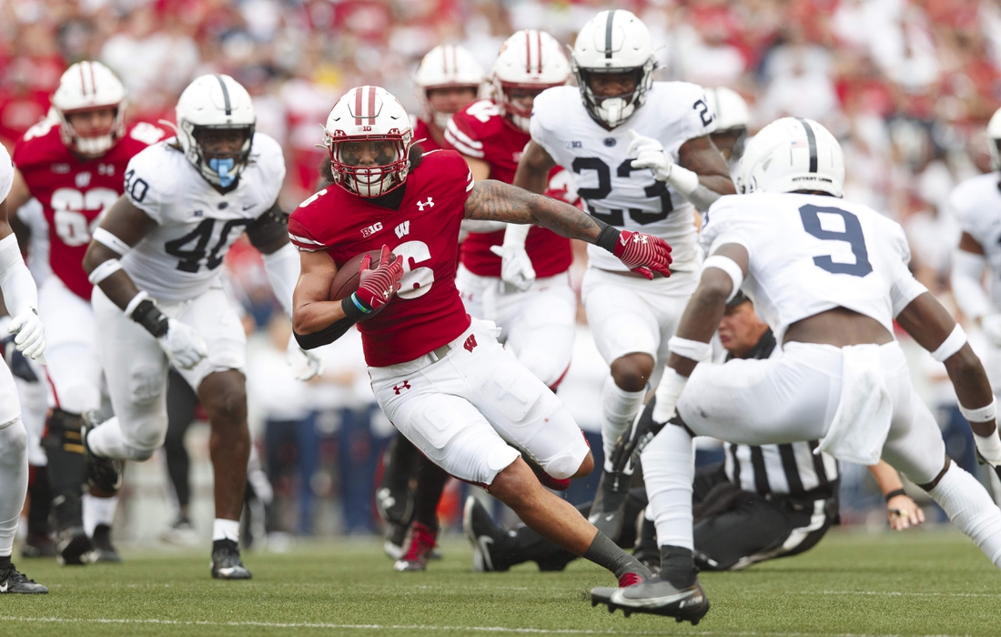 Sep 4, 2021; Madison, Wisconsin, USA;  Wisconsin Badgers running back Chez Mellusi (6) rushes with the football as Penn State Nittany Lions cornerback Joey Porter Jr. (9) defends during the first quarter at Camp Randall Stadium. Mandatory Credit: Jeff Hanisch-USA TODAY Sports