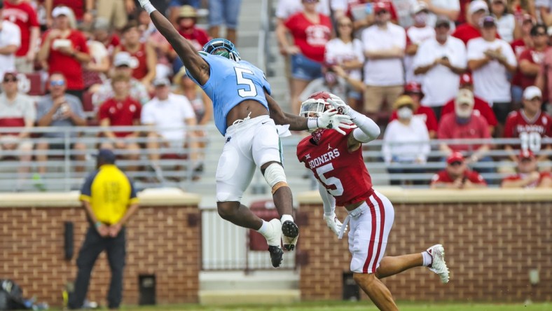 Sep 4, 2021; Norman, Oklahoma, USA;  Tulane Green Wave running back Ygenio Booker (5) makes a leaping catch in front of Oklahoma Sooners defensive back Billy Bowman (5) during the first quarter at Gaylord Family-Oklahoma Memorial Stadium. Mandatory Credit: Kevin Jairaj-USA TODAY Sports