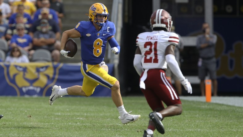 Sep 4, 2021; Pittsburgh, Pennsylvania, USA;  Pittsburgh Panthers quarterback Kenny Pickett (8) carries the ball against Massachusetts Minutemen defensive back Te'Rai Powell (21) during the first quarter at Heinz Field. Mandatory Credit: Charles LeClaire-USA TODAY Sports