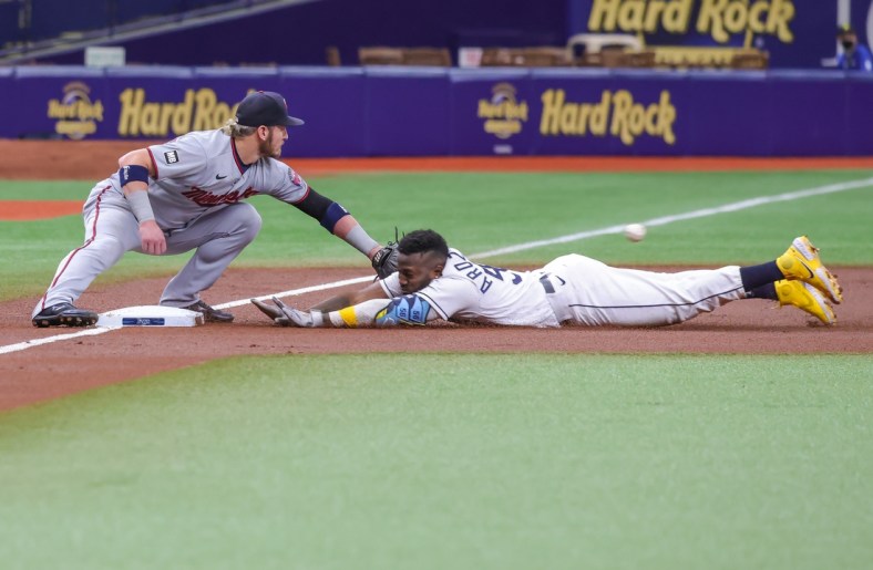 Sep 4, 2021; St. Petersburg, Florida, USA; Tampa Bay Rays left fielder Randy Arozarena (56) slides into third base against Minnesota Twins third baseman Josh Donaldson (20) during the first inning at Tropicana Field. Mandatory Credit: Mike Watters-USA TODAY Sports