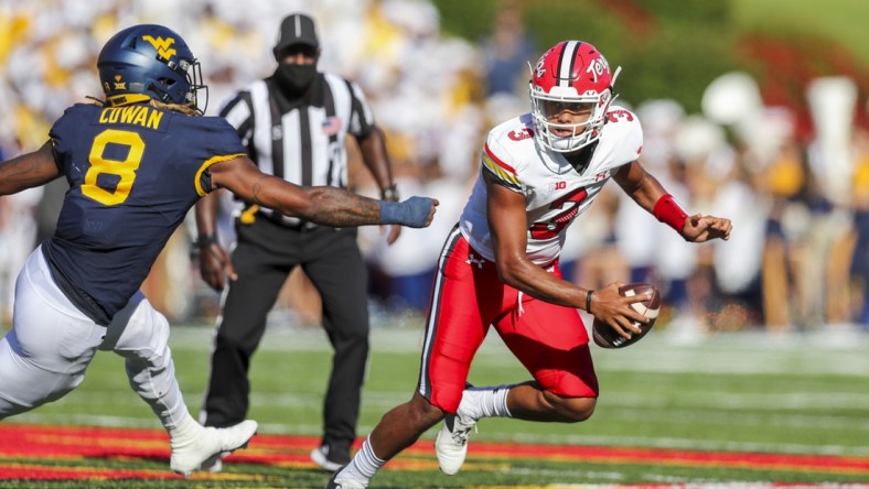 Sep 4, 2021; College Park, Maryland, USA; Maryland Terrapins quarterback Taulia Tagovailoa (3) escapes the pocket and pressure from West Virginia Mountaineers linebacker VanDarius Cowan (8) during the second quarter at Capital One Field at Maryland Stadium. Mandatory Credit: Ben Queen-USA TODAY Sports