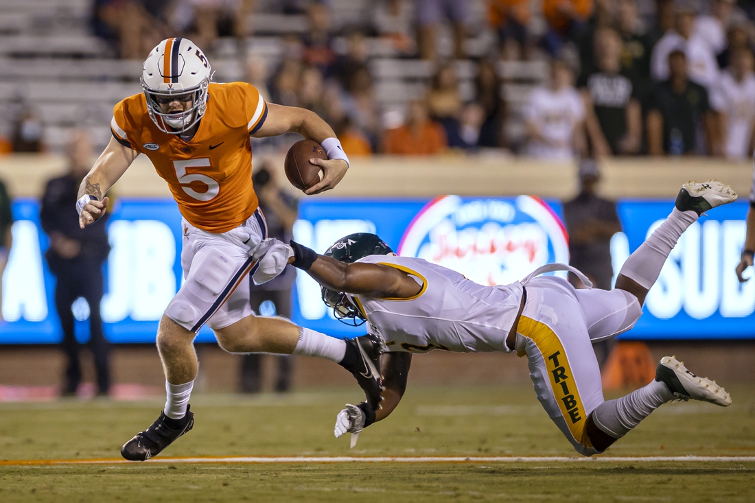 Sep 4, 2021; Charlottesville, Virginia, USA; Virginia Cavaliers quarterback Brennan Armstrong (5) scrambles against William & Mary Tribe linebacker Trey Watkins (2) during the first half at Scott Stadium. Mandatory Credit: Scott Taetsch-USA TODAY Sports