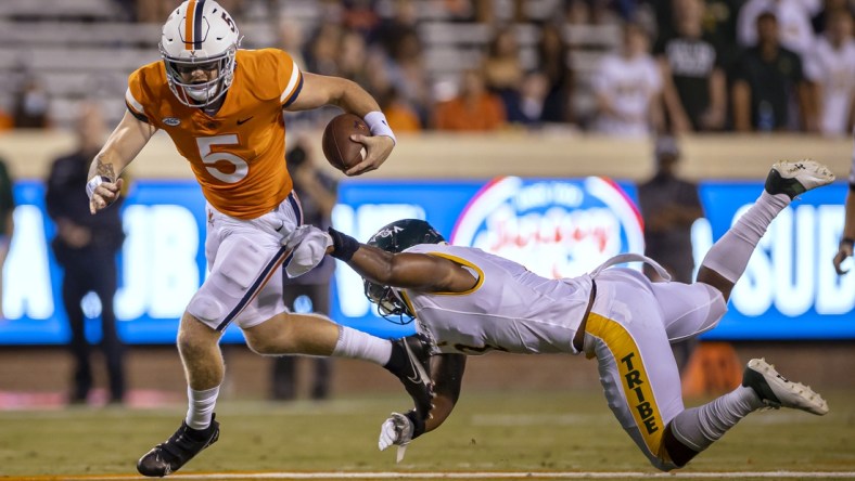 Sep 4, 2021; Charlottesville, Virginia, USA; Virginia Cavaliers quarterback Brennan Armstrong (5) scrambles against William & Mary Tribe linebacker Trey Watkins (2) during the first half at Scott Stadium. Mandatory Credit: Scott Taetsch-USA TODAY Sports