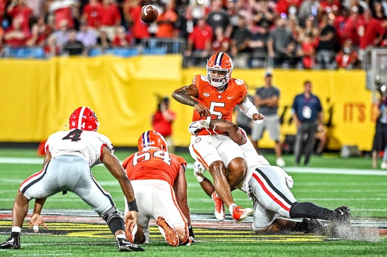 zSep 4, 2021; Charlotte, North Carolina, USA; Clemson Tigers quarterback D.J. Uiagalelei (5) is hit while he throws the ball during the second quarter against the Georgia Bulldogs at Bank of America Stadium. Mandatory Credit: Griffin Zetterberg-USA TODAY Sports
