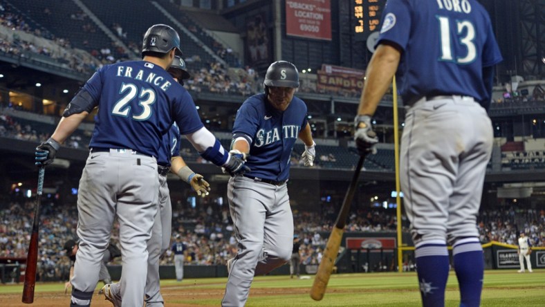 Sep 4, 2021; Phoenix, Arizona, USA; Seattle Mariners third baseman Kyle Seager (15) slaps hands with teammates after hitting a three run home run against the Arizona Diamondbacks during the sixth inning at Chase Field. Mandatory Credit: Joe Camporeale-USA TODAY Sports