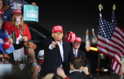 U.S. President Donald Trump tosses a Make America Great Again hat into a crowd of thousands after speaking at the Des Moines International Airport during a rally in Iowa on Wednesday, Oct. 14, 2020.

20201014 Trumpiowa
