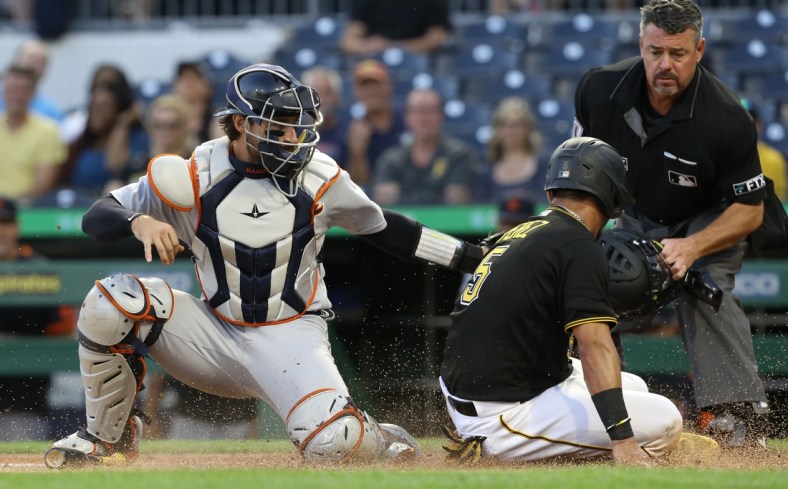 Sep 7, 2021; Pittsburgh, Pennsylvania, USA;  Detroit Tigers catcher Eric Haase (13) tags Pittsburgh Pirates catcher Michael Perez (5) out at home plate attempting to score during the second inning at PNC Park. Mandatory Credit: Charles LeClaire-USA TODAY Sports
