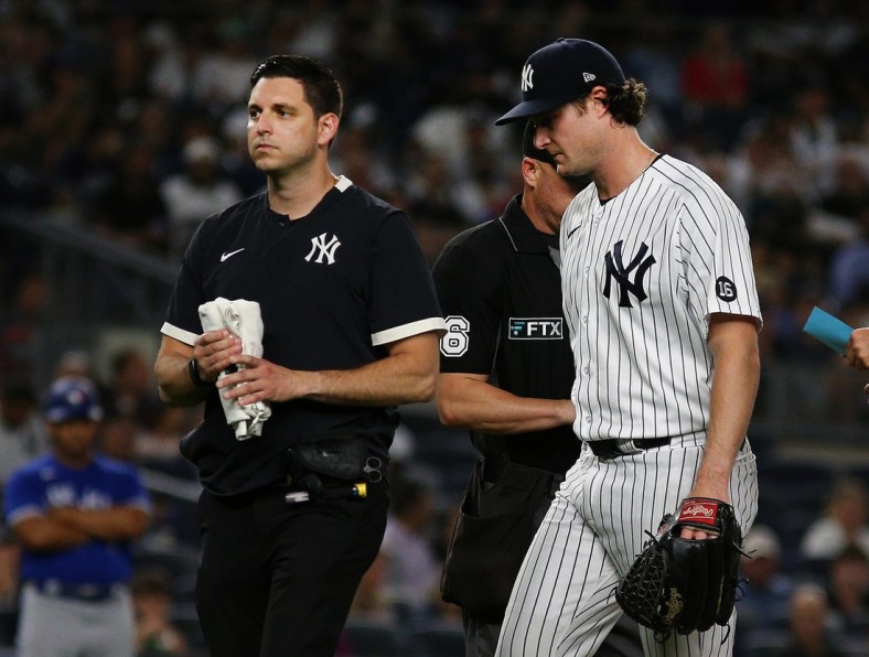 Sep 7, 2021; Bronx, New York, USA; New York Yankees starting pitcher Gerrit Cole (45) leaves the field with the trainer against the Toronto Blue Jays during the fourth inning at Yankee Stadium. Mandatory Credit: Andy Marlin-USA TODAY Sports