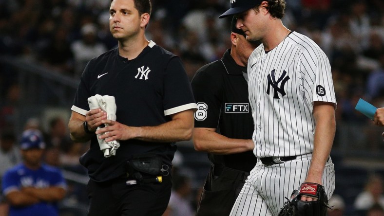 Sep 7, 2021; Bronx, New York, USA; New York Yankees starting pitcher Gerrit Cole (45) leaves the field with the trainer against the Toronto Blue Jays during the fourth inning at Yankee Stadium. Mandatory Credit: Andy Marlin-USA TODAY Sports