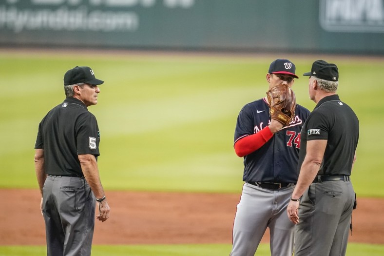 Sep 8, 2021; Cumberland, Georgia, USA; Washington Nationals starting pitcher Sean Nolin (74) speaks with the umpires following his ejection for hitting Atlanta Braves first baseman Freddie Freeman (not shown) with a pitch during the first inning at Truist Park. Mandatory Credit: Dale Zanine-USA TODAY Sports