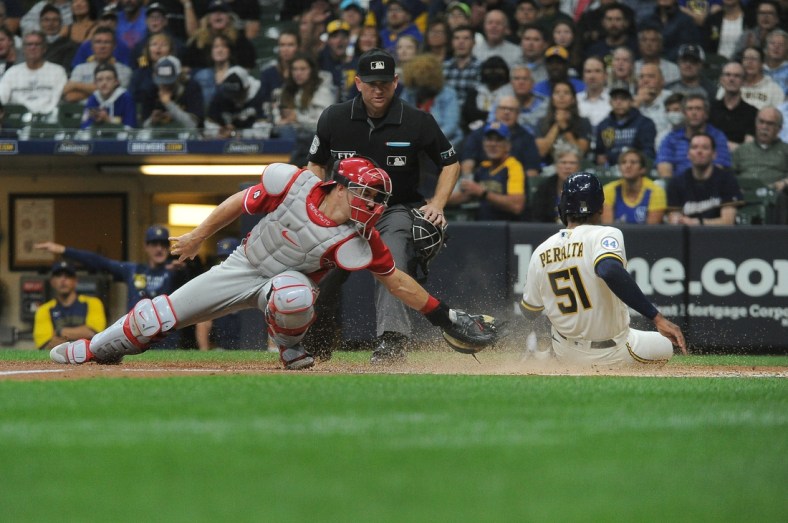 Sep 8, 2021; Milwaukee, Wisconsin, USA;  Milwaukee Brewers relief pitcher Freddy Peralta (51) slides in safely into home plate against the Philadelphia Phillies catcher J.T. Realmuto (10) in the second inning at American Family Field. Mandatory Credit: Michael McLoone-USA TODAY Sports