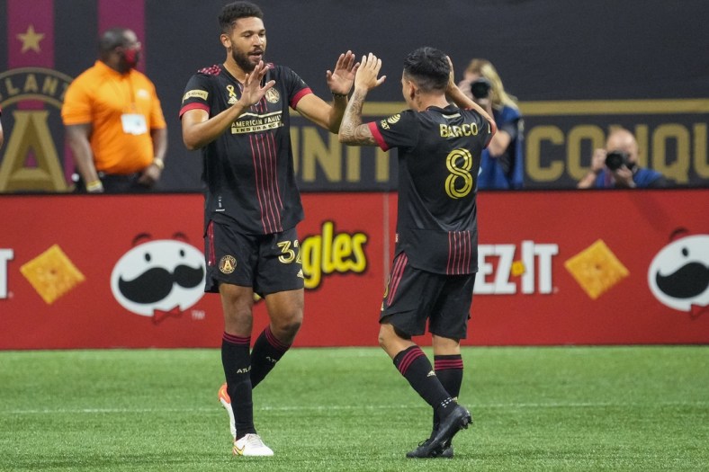 Sep 10, 2021; Atlanta, Georgia, USA; Atlanta United defender George Campbell (32) reacts with midfielder Ezequiel Barco (8) after scoring a goal against Orlando City during the first half at Mercedes-Benz Stadium. Mandatory Credit: Dale Zanine-USA TODAY Sports