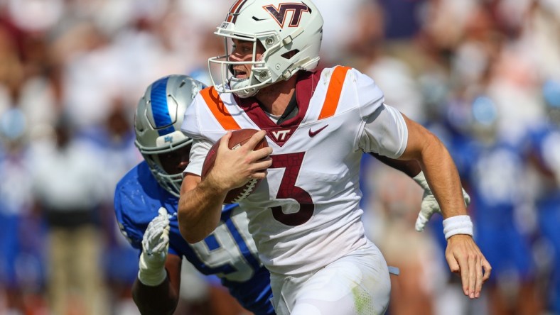 Sep 11, 2021; Blacksburg, Virginia, USA;  Virginia Tech Hokies quarterback Braxton Burmeister (3) runs the ball against Middle Tennessee Blue Raiders defensive lineman Zaylin Wood (96) during the second quarter at Lane Stadium. Mandatory Credit: Ryan Hunt-USA TODAY Sports