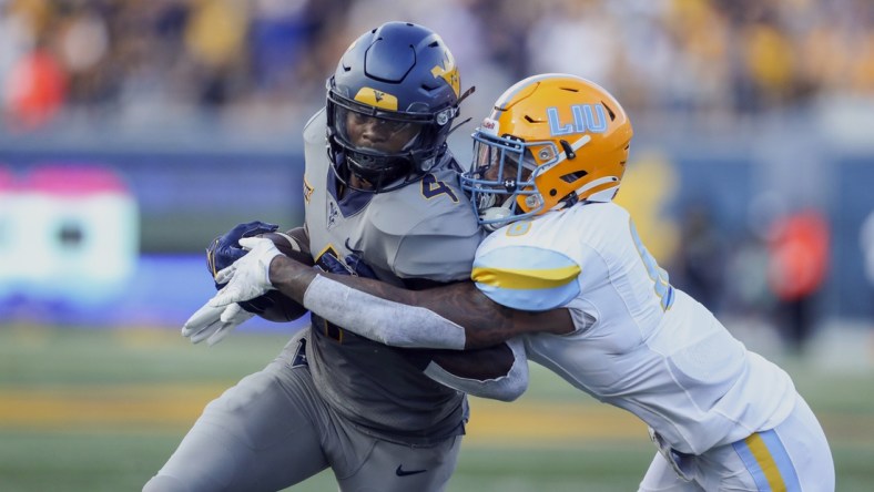 Sep 11, 2021; Morgantown, West Virginia, USA; West Virginia Mountaineers running back Leddie Brown (4) is tackled by Long Island Sharks safety Jerome Brooks III (6) during the second quarter at Mountaineer Field at Milan Puskar Stadium. Mandatory Credit: Ben Queen-USA TODAY Sports