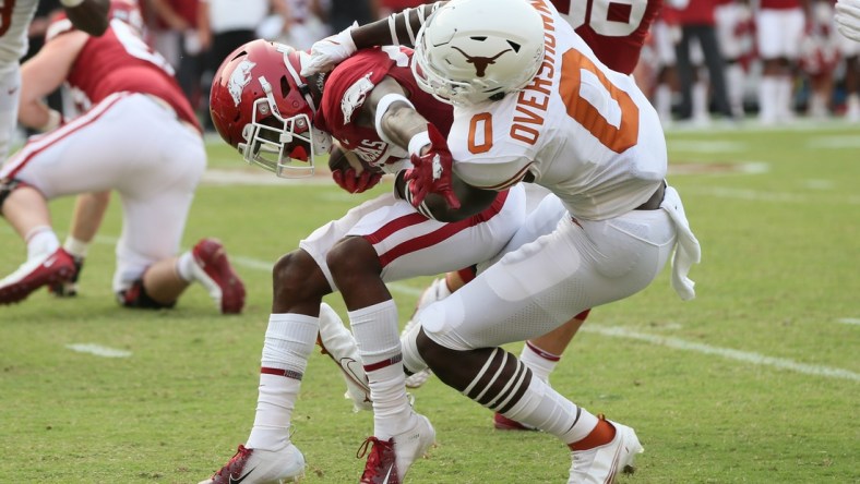 Sep 11, 2021; Fayetteville, Arkansas, USA; Texas Longhorns linebacker DeMarvion Overshow (0) tackles Arkansas Razorbacks running back Trelon Smith (22) during the first quarter at Donald W. Reynolds Razorback Stadium. Mandatory Credit: Nelson Chenault-USA TODAY Sports