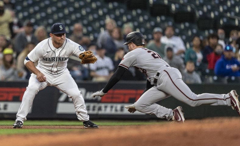 Sep 11, 2021; Seattle, Washington, USA;  Seattle Mariners third baseman Kyle Seager (15) tags out Arizona Diamondbacks first baseman Pavin Smith (26) after Smith tagged up on a fly ball during the fourth inning at T-Mobile Park. Mandatory Credit: Stephen Brashear-USA TODAY Sports