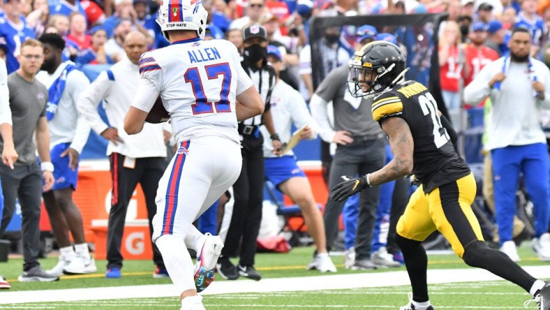 Sep 12, 2021; Orchard Park, New York, USA; Buffalo Bills quarterback Josh Allen (17) tries to outrun Pittsburgh Steelers cornerback Tre Norwood (21) in the first quarter of a game at Highmark Stadium. Mandatory Credit: Mark Konezny-USA TODAY Sports