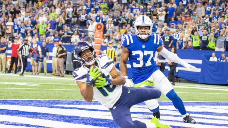 Sep 12, 2021; Indianapolis, Indiana, USA; Seattle Seahawks wide receiver Tyler Lockett (16) catches a touchdown pass while Indianapolis Colts safety Khari Willis (37) defends in the first quarter at Lucas Oil Stadium. Mandatory Credit: Trevor Ruszkowski-USA TODAY Sports