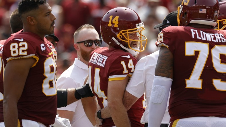 Sep 12, 2021; Landover, Maryland, USA; Washington Football Team quarterback Ryan Fitzpatrick (14) is helped off the field after being inured against the Los Angeles Chargers in the second quarter at FedExField. Mandatory Credit: Geoff Burke-USA TODAY Sports