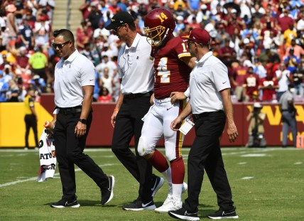 Sep 12, 2021; Landover, Maryland, USA; Washington Football Team quarterback Ryan Fitzpatrick (14) is helped off the field after suffering an injury during the second quarter against the Los Angeles Chargers at FedExField. Mandatory Credit: Brad Mills-USA TODAY Sports
