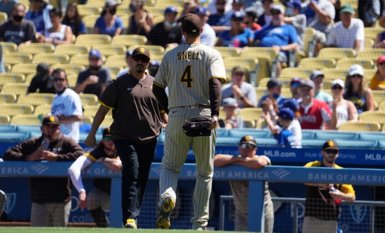 Sep 12, 2021; Los Angeles, California, USA; San Diego Padres trainer walks out of the dugout to meet San Diego Padres starting pitcher Blake Snell (4) after Snell injured himself throwing a pitch in the first inning against the Los Angeles Dodgers at Dodger Stadium. Mandatory Credit: Robert Hanashiro-USA TODAY Sports