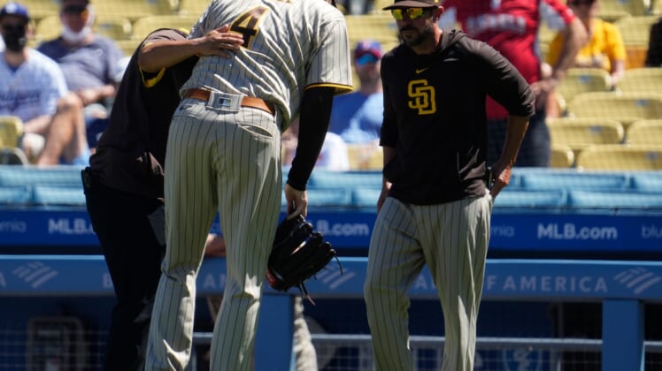Sep 12, 2021; Los Angeles, California, USA; San Diego Padres starting pitcher Blake Snell (4) is helped off the field by a team trainer after apparently injuring himself throwing a pitch in the first inning against the Los Angeles Dodgers at Dodger Stadium. Mandatory Credit: Robert Hanashiro-USA TODAY Sports