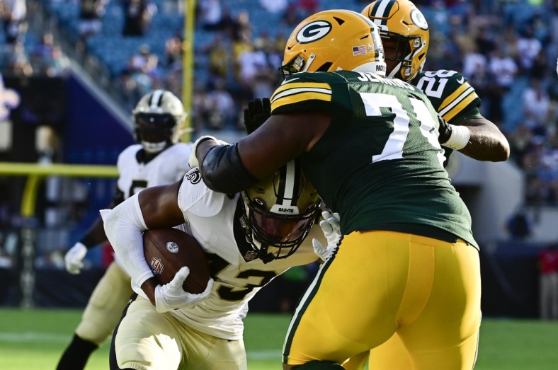 Sep 12, 2021; Jacksonville, Florida, USA;  Green Bay Packers guard Elgton Jenkins (74) tackles New Orleans Saints safety Marcus Williams (43) along the sideline during the third quarter at TIAA Bank Field. Mandatory Credit: Tommy Gilligan-USA TODAY Sports