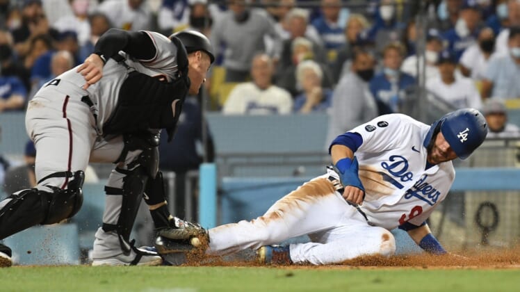 Sep 13, 2021; Los Angeles, California, USA; Los Angeles Dodgers second baseman Gavin Lux (9) is out at home trying to score against Arizona Diamondbacks catcher Carson Kelly (18) in the fourth inning on a sacrifice fly hit by Los Angeles Dodgers right fielder Mookie Betts (not pictured)  at Dodger Stadium. Mandatory Credit: Richard Mackson-USA TODAY Sports