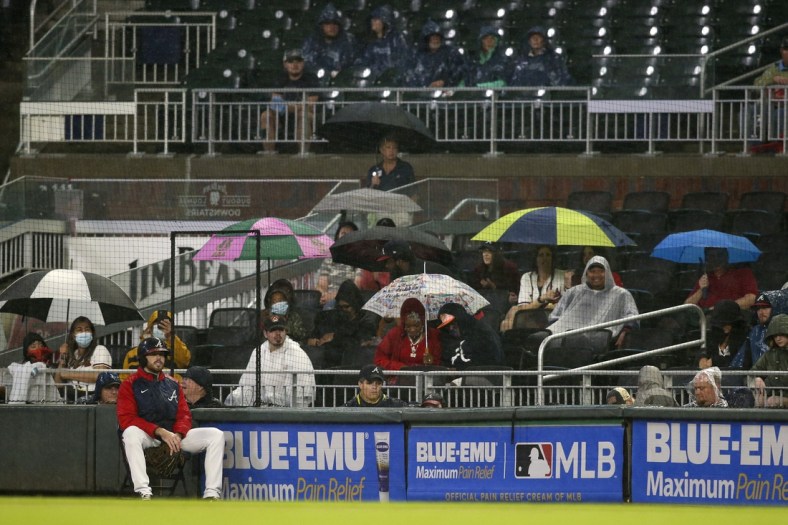 Sep 15, 2021; Atlanta, Georgia, USA; Fans watch a game between the Atlanta Braves and Colorado Rockies with umbrellas in the rain in the second inning at Truist Park. Mandatory Credit: Brett Davis-USA TODAY Sports