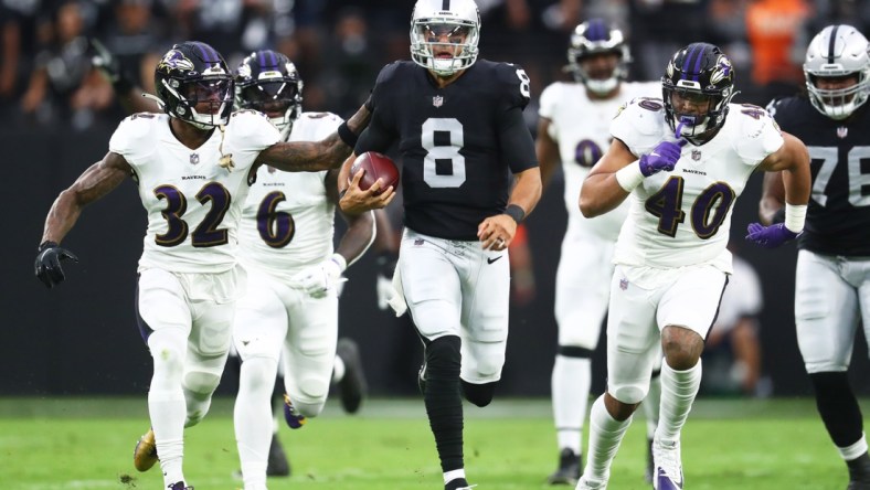 Sep 13, 2021; Paradise, Nevada, USA; Las Vegas Raiders quarterback Marcus Mariota (8) runs the ball ahead of Baltimore Ravens linebacker Patrick Queen (6) defensive back DeShon Elliott (32) and linebacker Malik Harrison (40) during the first half at Allegiant Stadium. Mandatory Credit: Mark J. Rebilas-USA TODAY Sports