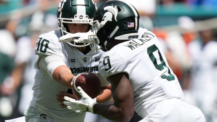 Sep 18, 2021; Miami Gardens, Florida, USA; Michigan State Spartans quarterback Payton Thorne (10) hands the ball to running back Kenneth Walker III (9) during the first half against the Miami Hurricanes at Hard Rock Stadium. Mandatory Credit: Jasen Vinlove-USA TODAY Sports