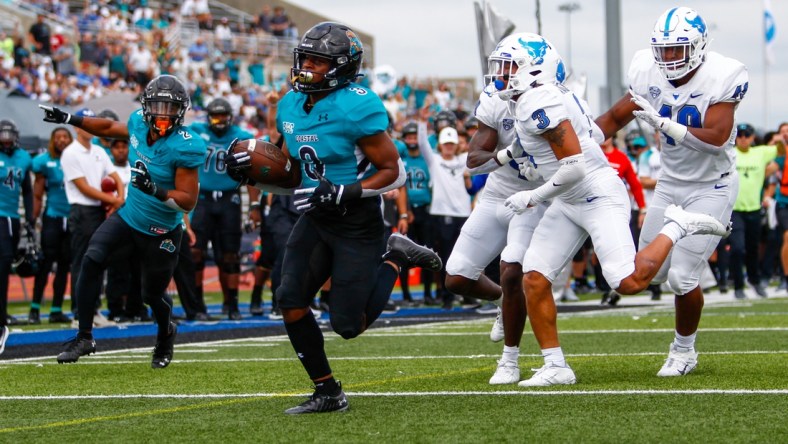 Sep 18, 2021; Buffalo, New York, USA; Coastal Carolina Chanticleers wide receiver Aaron Bedgood (3) turns the ball up field and out runs Buffalo Bulls defensive end Taylor Riggins (49) and cornerback Aapri Washington (3) to score a touchdown giving the Chanticleers an early 7-0 lead during the first quarter of play at UB Stadium. Mandatory Credit: Nicholas LoVerde-USA TODAY Sports