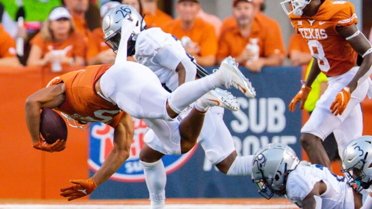 Sep 18, 2021; Austin, Texas; Texas Longhorns running back Bijan Robinson (5) goes airborne after being tripped up by Rice Owl defenders during the first quarter at Darrell K Royal-Texas Memorial Stadium. Mandatory Credit: John Gutierrez-USA TODAY Sports