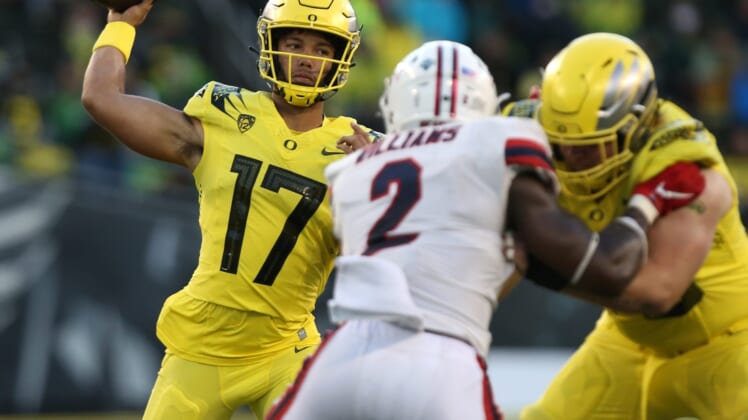 Oregon's Ty Thompson, left, throws down field against Stony Brook during the third quarter.Eug 091821 Oregonfb 14
