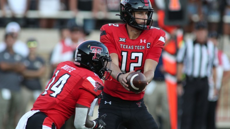 Sep 18, 2021; Lubbock, Texas, USA; Texas Tech Red Raiders quarter back Tyler Shough (12) hands off to running back Xavier White (14) against the Florida International Panthers during the first half at Jones AT&T Stadium. Mandatory Credit: Michael C. Johnson-USA TODAY Sports