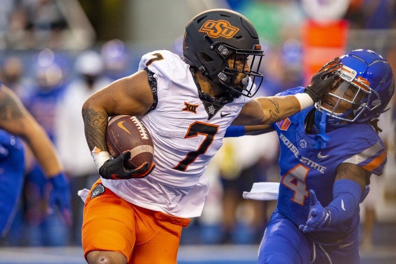Sep 18, 2021; Boise, Idaho, USA;  Boise State Broncos safety Rodney Robinson (4) gets a stiff arm from Oklahoma State Cowboys running back Jaylen Warren (7) during the first half of play  at Albertsons Stadium. Mandatory Credit: Brian Losness-USA TODAY Sports
