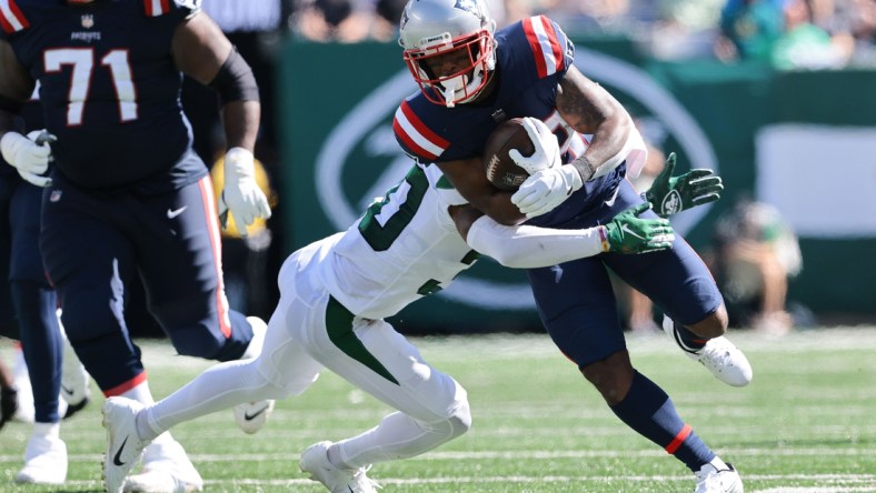 Sep 19, 2021; East Rutherford, New Jersey, USA; New England Patriots running back James White (28) carries the ball as New York Jets cornerback Michael Carter II (30) tackles during the first half at MetLife Stadium. Mandatory Credit: Vincent Carchietta-USA TODAY Sports