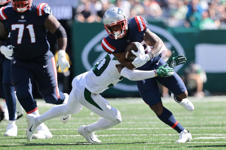 Sep 19, 2021; East Rutherford, New Jersey, USA; New England Patriots running back James White (28) carries the ball as New York Jets cornerback Michael Carter II (30) tackles during the first half at MetLife Stadium. Mandatory Credit: Vincent Carchietta-USA TODAY Sports