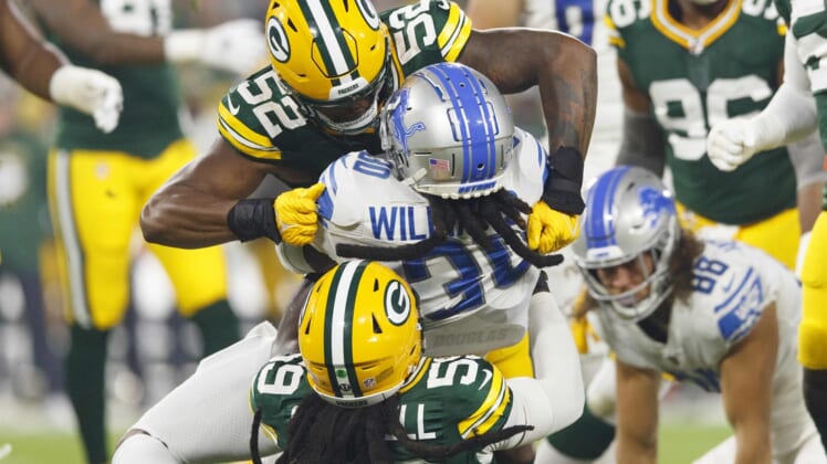Sep 20, 2021; Green Bay, Wisconsin, USA;  Detroit Lions running back Jamaal Williams (30) is tackled by Green Bay Packers outside linebackers Rashan Gary (52) and Isaiah McDuffie (58) during the first quarter at Lambeau Field. Mandatory Credit: Jeff Hanisch-USA TODAY Sports