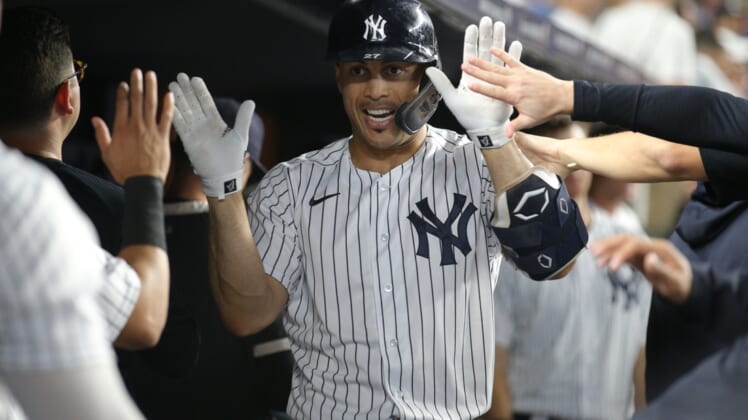 Sep 21, 2021; Bronx, New York, USA; New York Yankees right fielder Giancarlo Stanton (27) celebrates in the dugout with teammates after hitting a solo home run against the Texas Rangers during the third inning at Yankee Stadium. Mandatory Credit: Brad Penner-USA TODAY Sports