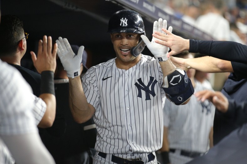 Sep 21, 2021; Bronx, New York, USA; New York Yankees right fielder Giancarlo Stanton (27) celebrates in the dugout with teammates after hitting a solo home run against the Texas Rangers during the third inning at Yankee Stadium. Mandatory Credit: Brad Penner-USA TODAY Sports