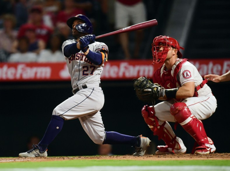 Sep 21, 2021; Anaheim, California, USA; Houston Astros second baseman Jose Altuve (27) hits a two run home run against the Los Angeles Angels during the fifth inning at Angel Stadium. Mandatory Credit: Gary A. Vasquez-USA TODAY Sports