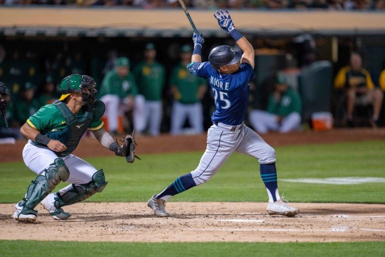 Sep 21, 2021; Oakland, California, USA;  Seattle Mariners second baseman Dylan Moore (25) hits a two run RBI triple during the fourth inning against the Oakland Athletics at RingCentral Coliseum. Mandatory Credit: Neville E. Guard-USA TODAY Sports