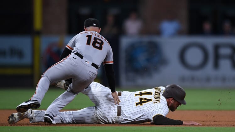 Sep 21, 2021; San Diego, California, USA; San Diego Padres starting pitcher Joe Musgrove (44) is tagged out by San Francisco Giants second baseman Tommy La Stella (18) after being caught in a rundown during the fourth inning at Petco Park. Mandatory Credit: Orlando Ramirez-USA TODAY Sports